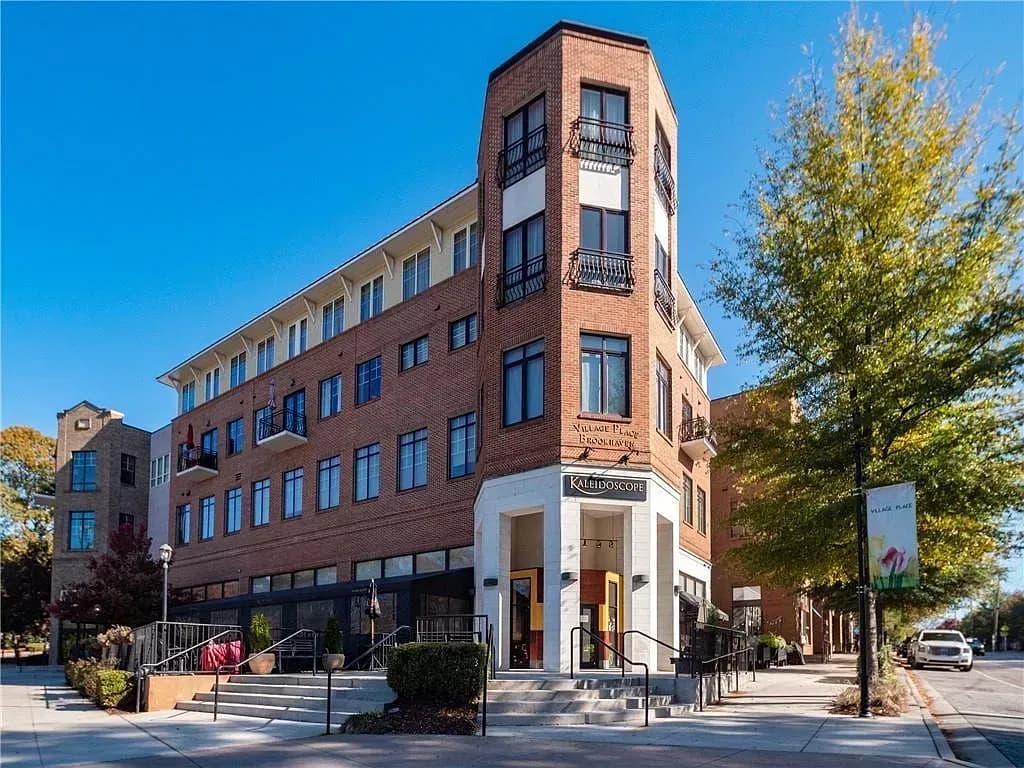 Red brick corner building with retail storefront on ground floor and residential units above